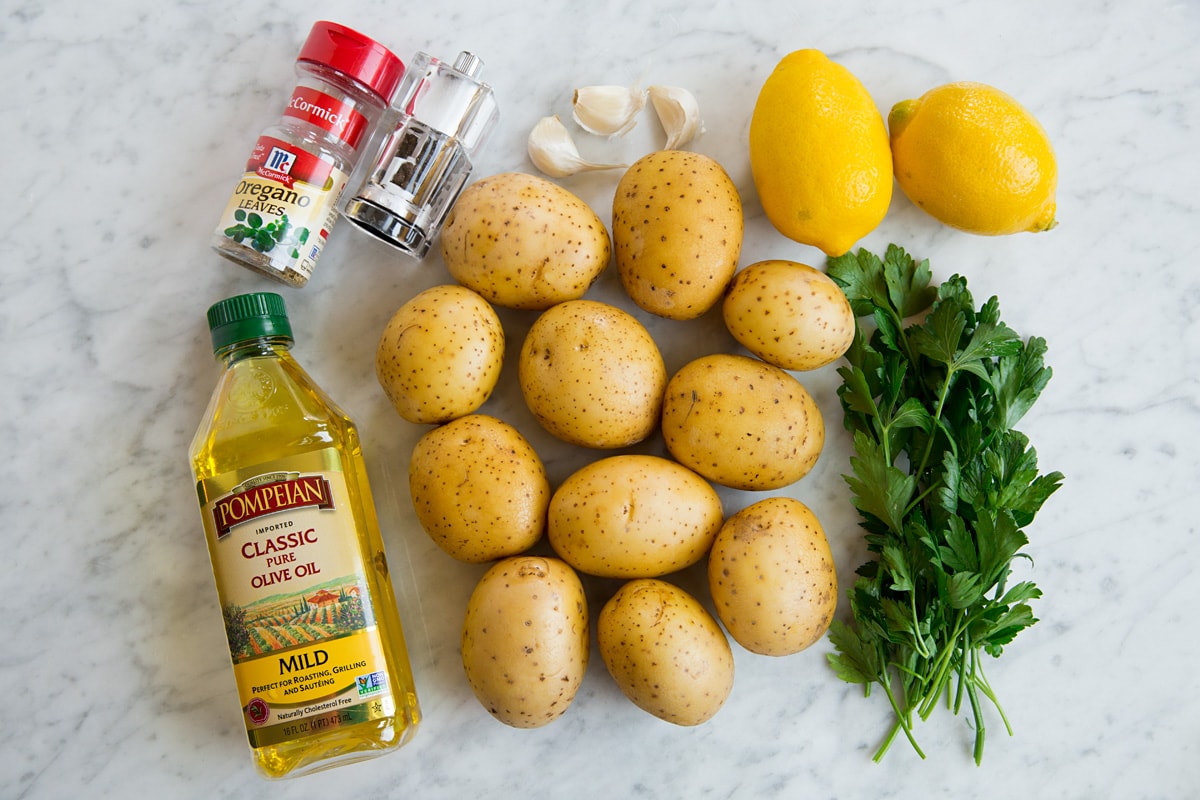 Lemon Roasted Potatoes Image of ingredients used to make lemon potatoes including yukon gold potatoes, lemons, olive oil, garlic, oregano, salt, pepper and parsley.