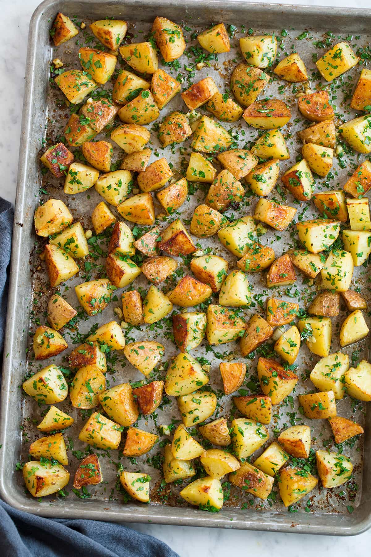 Lemon Roasted Potatoes. Lemon seasoned yukon roasted potatoes on a baking sheet shown overhead.