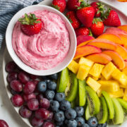 Easy cream cheese fruit dip in a bowl on a serving platter with fruit.
