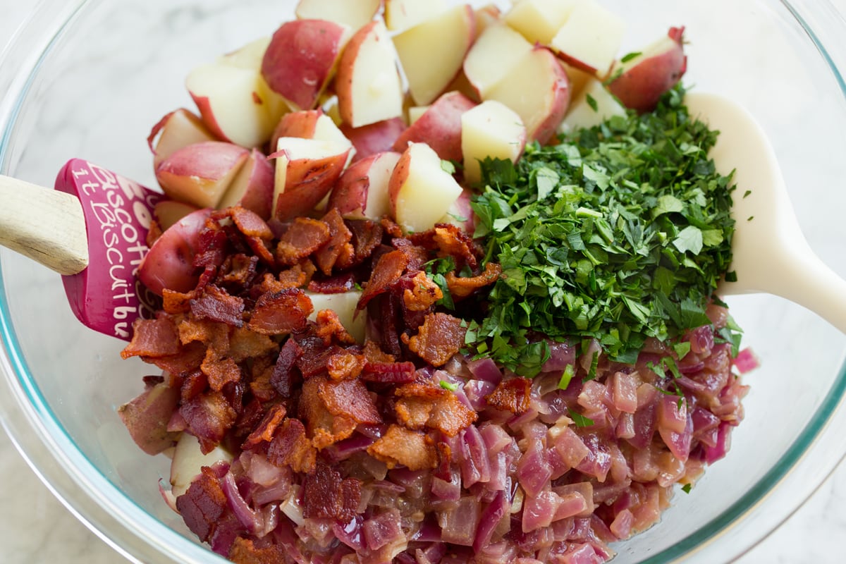 German Potato Salad Prepared German potato salad ingredients shown in a mixing bowl before tossing.