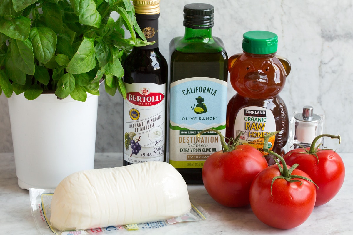 Caprese Salad Caprese Salad Ingredients shown in this image. Includes fresh mozzarella, fresh basil, fresh tomatoes, olive oil, honey, balsamic vinegar, salt and pepper.