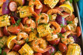 Image shown overhead of shrimp boil after cooking poured out and spread onto a large baking sheet.