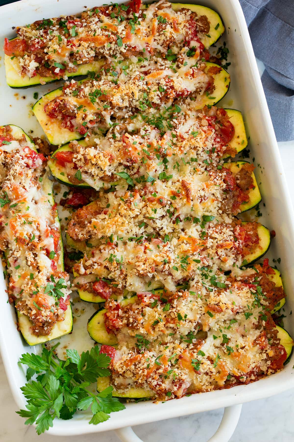 Zucchini Boats Overhead image of stuffed zucchini boats in a road in a white baking dish.