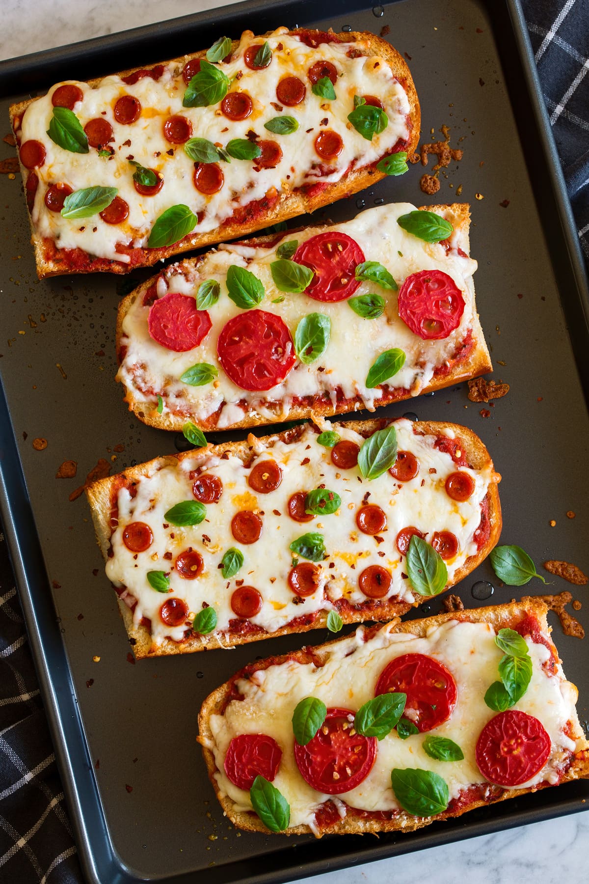 French Bread Pizza Overhead image of French Bread Pizza on a dark baking sheet.