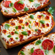 French Bread Pizza shown from a side angle on a baking sheet.