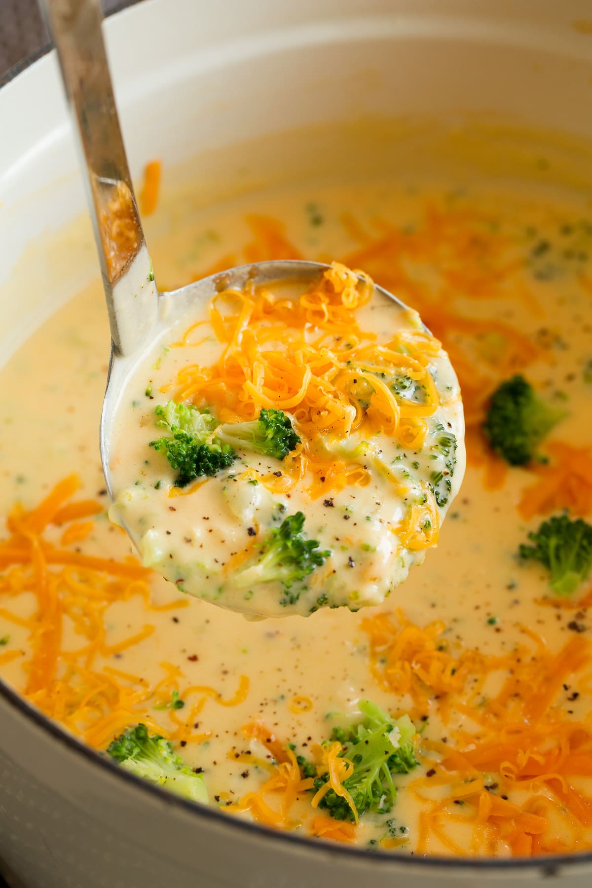 The BEST Broccoli Cheese Soup Ladle full of broccoli cheese soup lifted from a pot filled with soup.