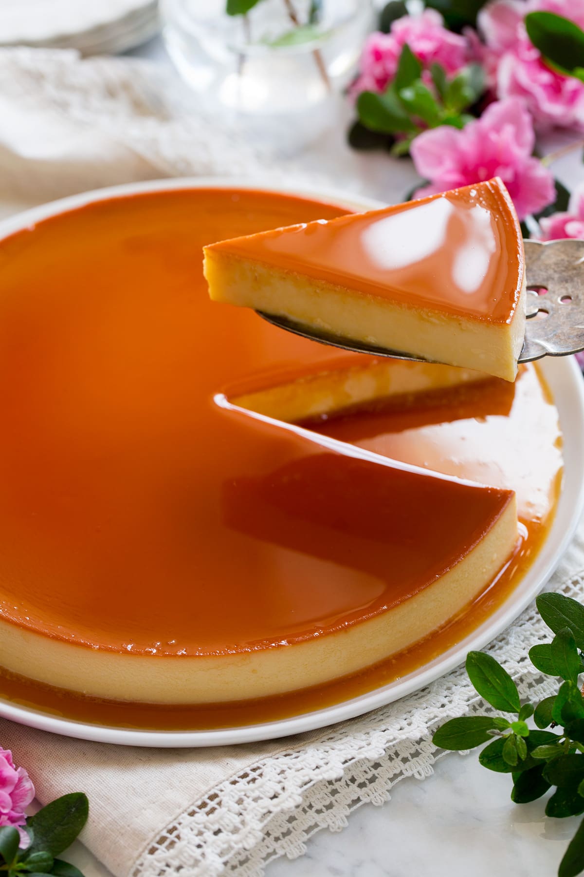 Flan Recipe Image showing server spatula removing slice from whole flan.