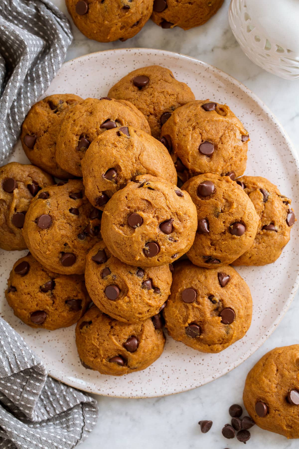 Pumpkin Chocolate Chip Cookies Pumpkin Chocolate Chip Cookies stacked on a plate and shown overhead.