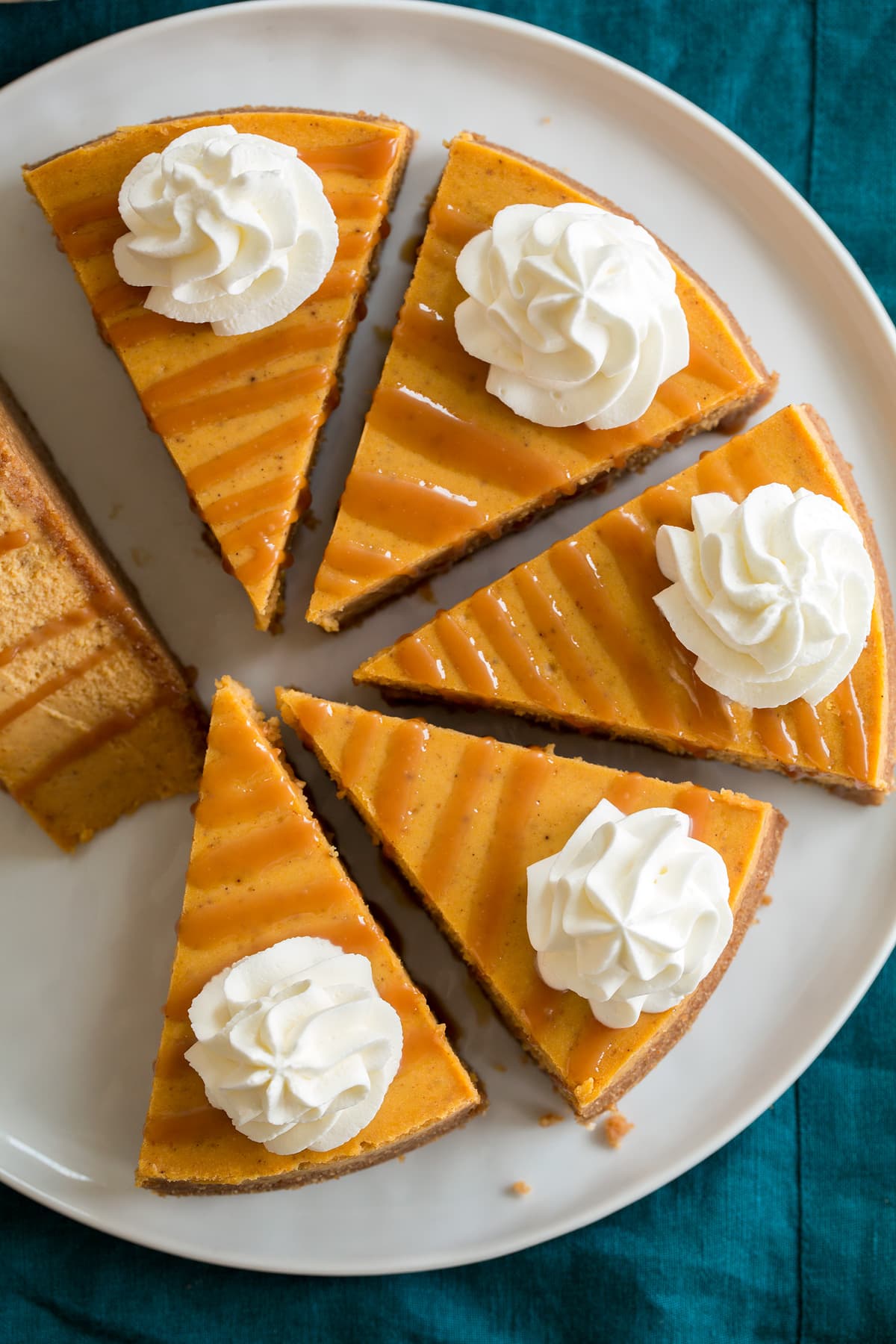 Pumpkin Cheesecake Overhead image of six slices of pumpkin cheesecake on a white serving platter.