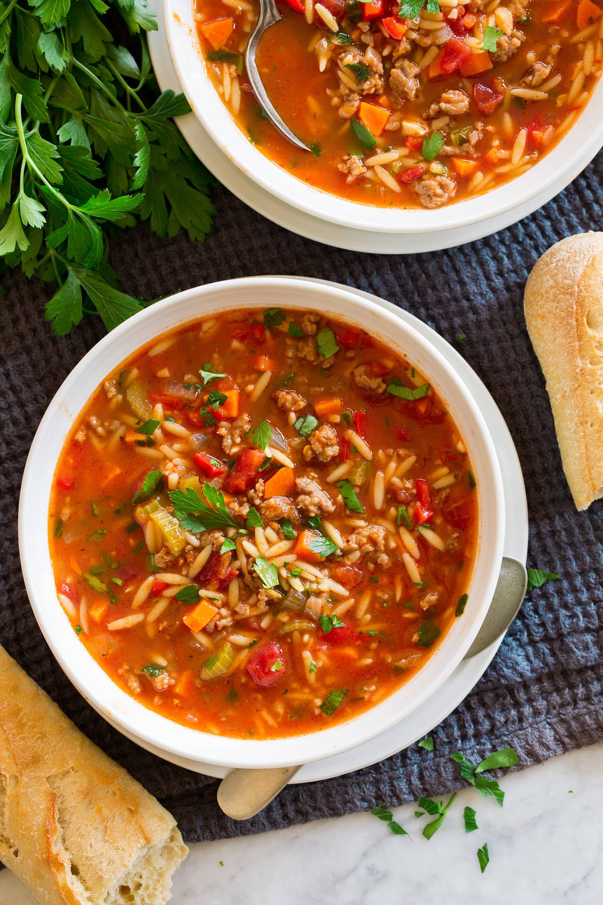 Italian Sausage Soup {with Orzo} Two servings of sausage soup shown in bowls.