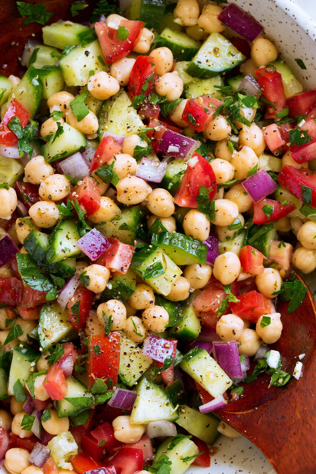 Chickpea Salad Close up overhead photo of Chickpea Salad with chickpeas, tomatoes, cucumbers, herbs and onion.