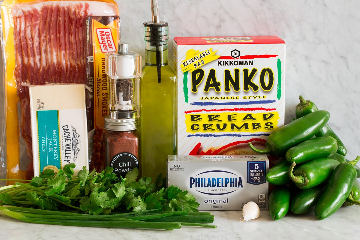 Jalapeno Poppers Photo of ingredients used to make jalapeno poppers. Includes fresh jalapenos, panko bread crumbs, cream cheese, garlic, cilantro, green onions, Monterey jack cheese, chili powder, salt, pepper and bacon.