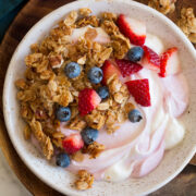 Granola, yogurt and fruit bowl shown from above.