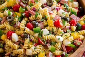 Italian pasta salad shown from a side angle on a large wooden bowl.