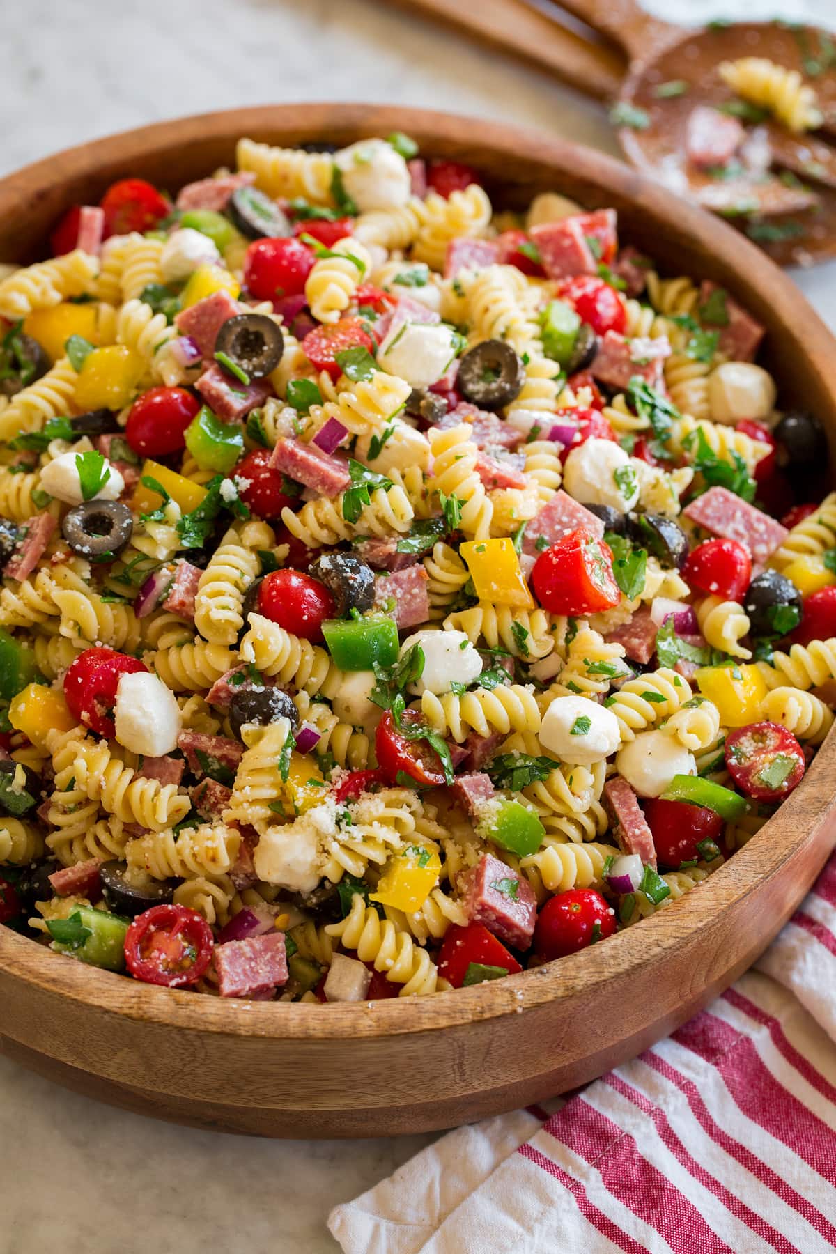 Pasta Salad Italian pasta salad shown from a side angle on a large wooden bowl.