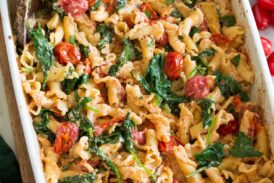 Photo: Baked feta pasta in a white rectangular baking dish shown from a side angle.