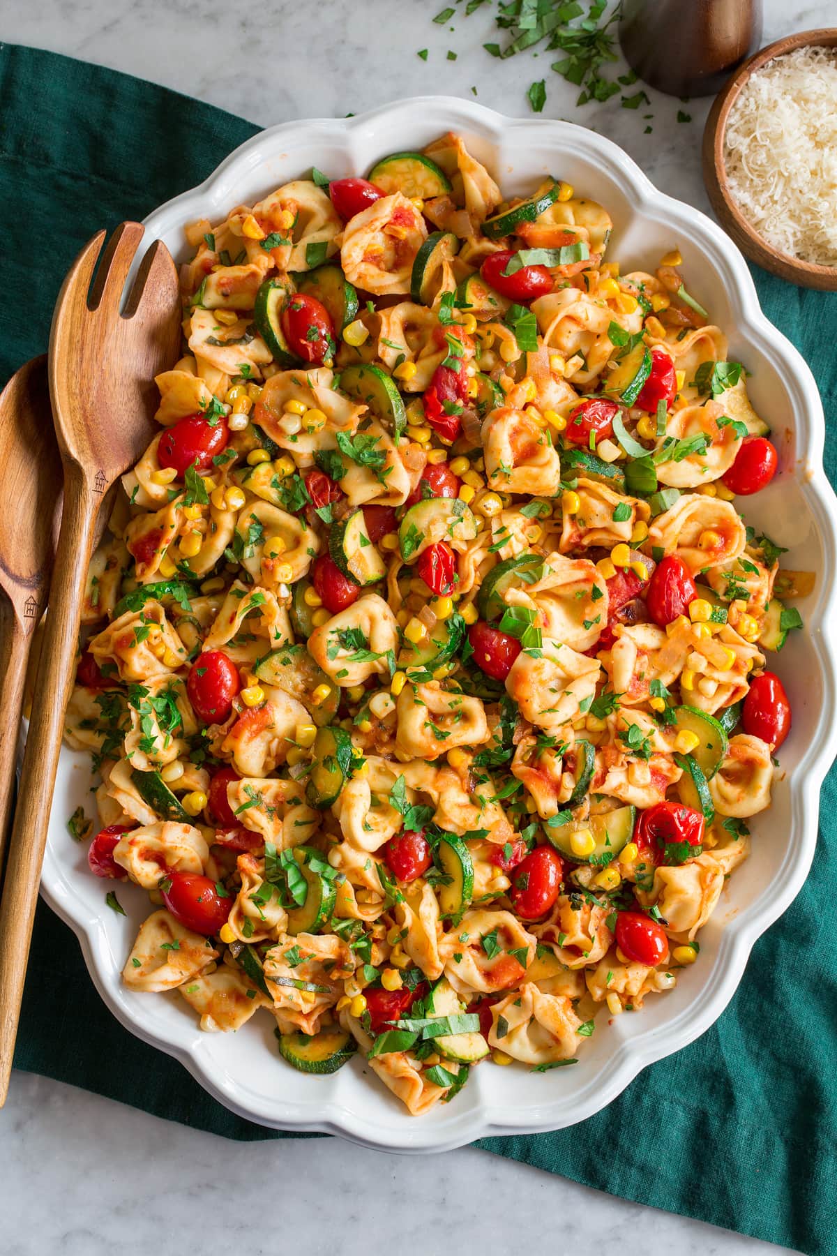 Cheese Tortellini with Summer Veggies Photo: Tortellini shown in an oval platter from overhead. Platter is on a green cloth on a marble surface.