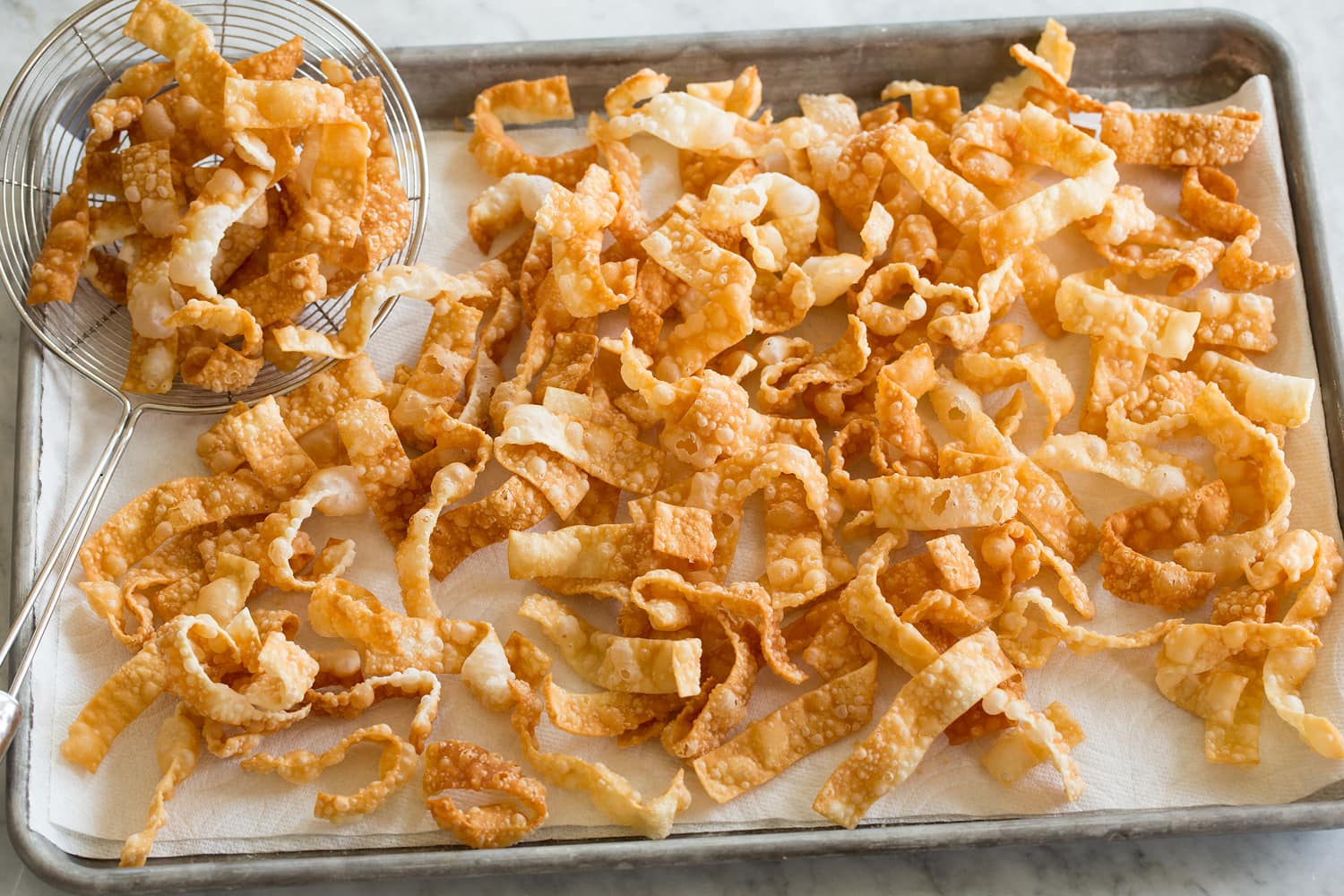 Fried Wonton Strips Wonton strips draining on paper towels.