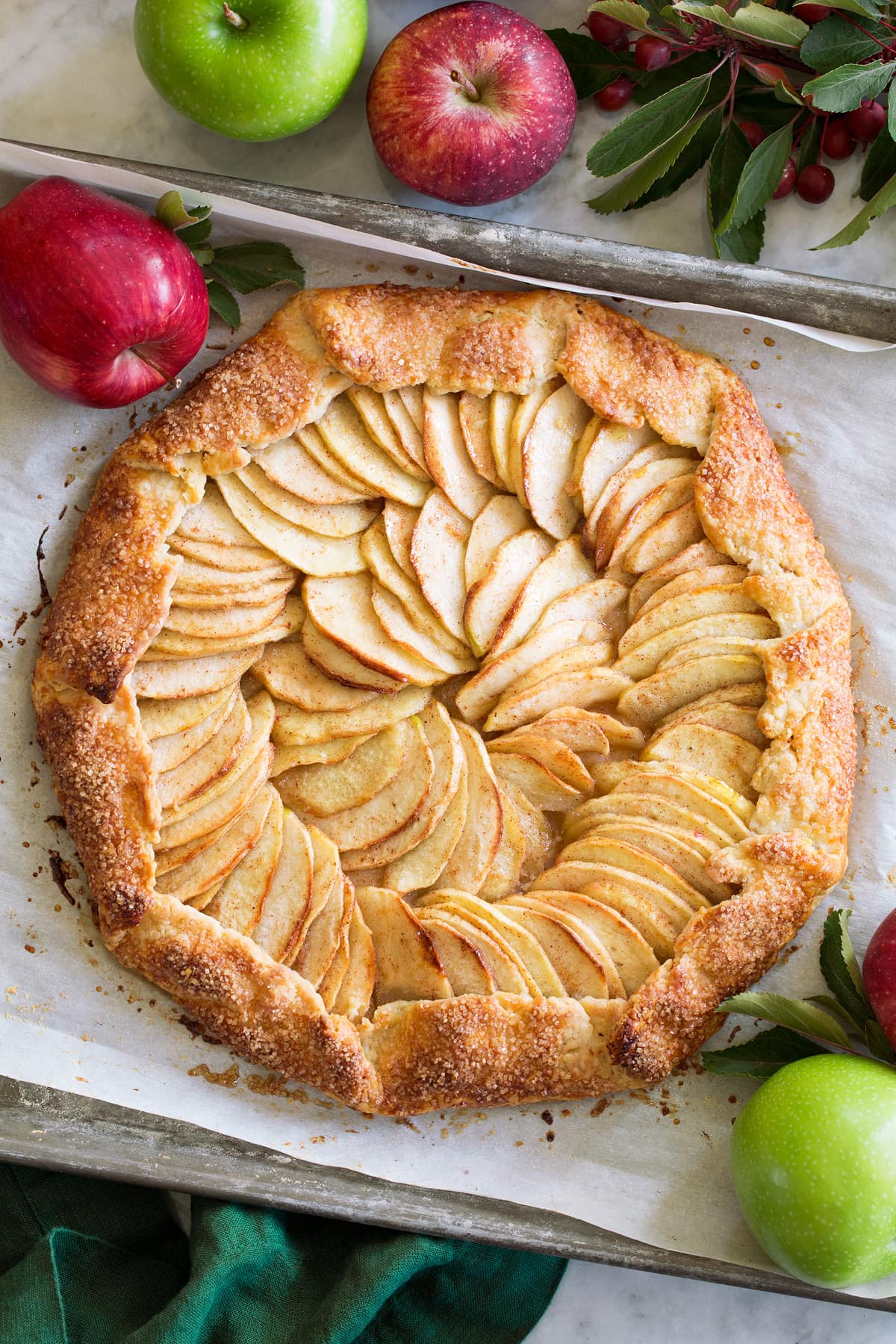 Apple Galette A whole Apple Galette shown from with fresh apples surrounding it.