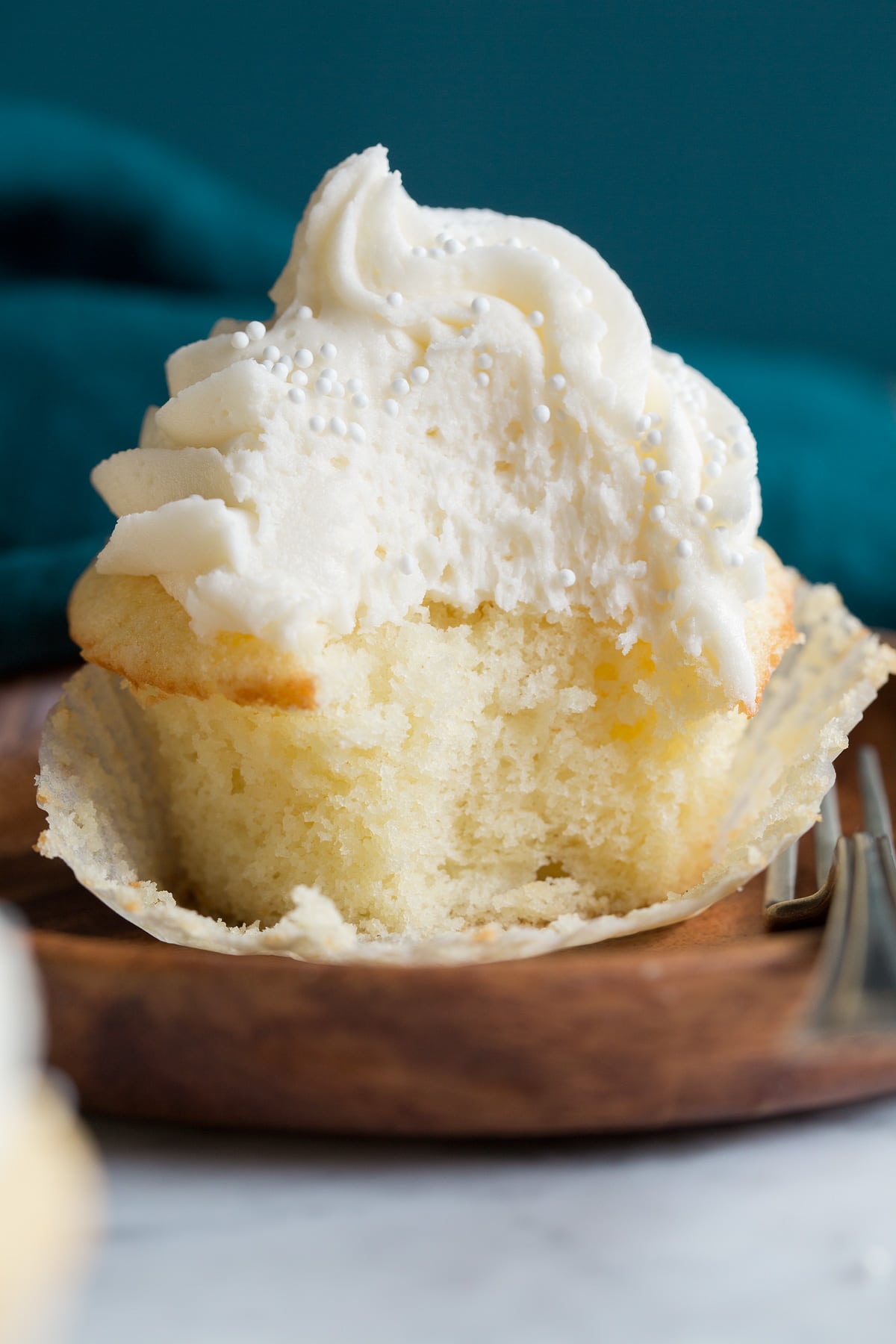 Vanilla Cupcakes Close up photo of a single cupcake that has been bitten into.