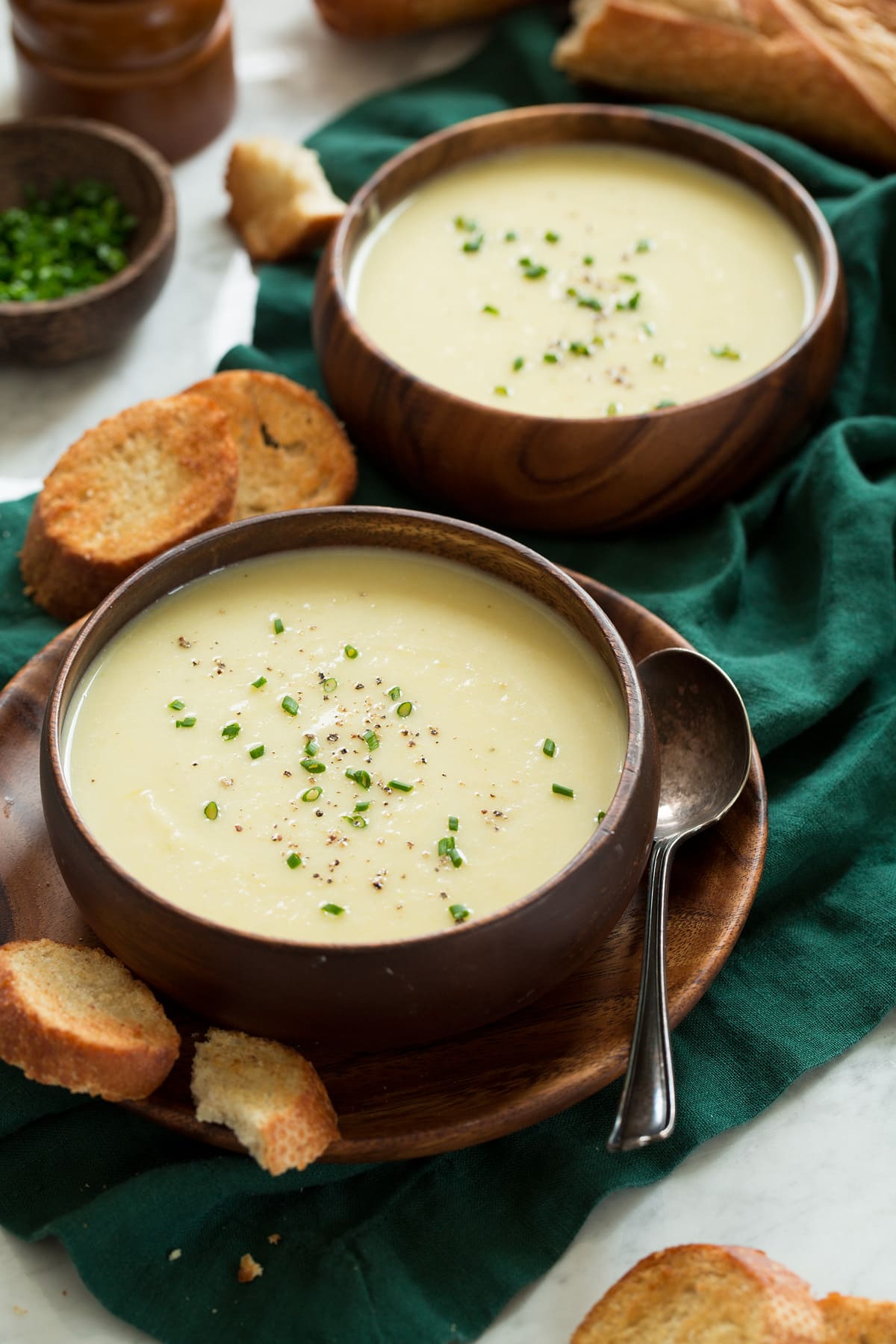 Potato Leek Soup Two serving of potato leek soup in wooden bowls.