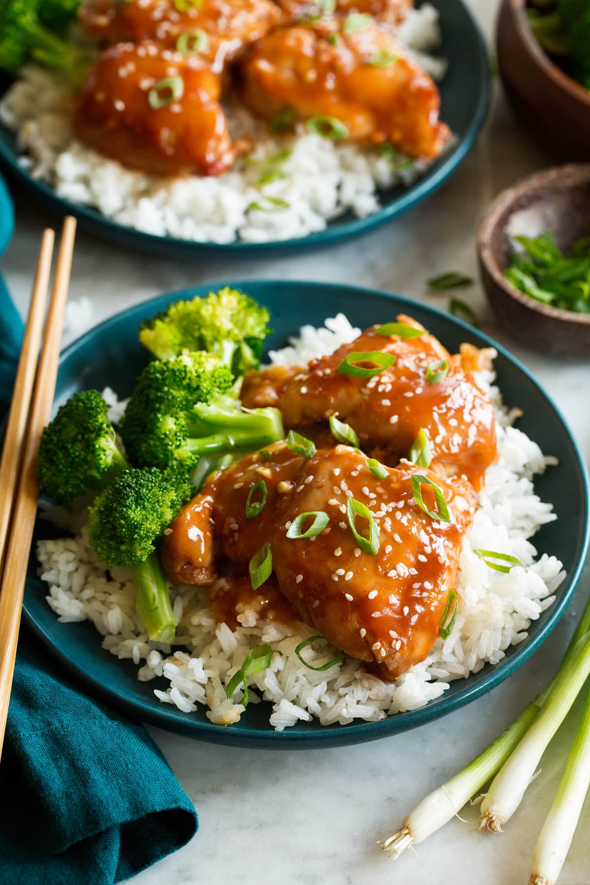 Slow Cooker Chicken Thighs Slow cooker chicken thighs coated in a sauce shown served with white rice and broccoli.