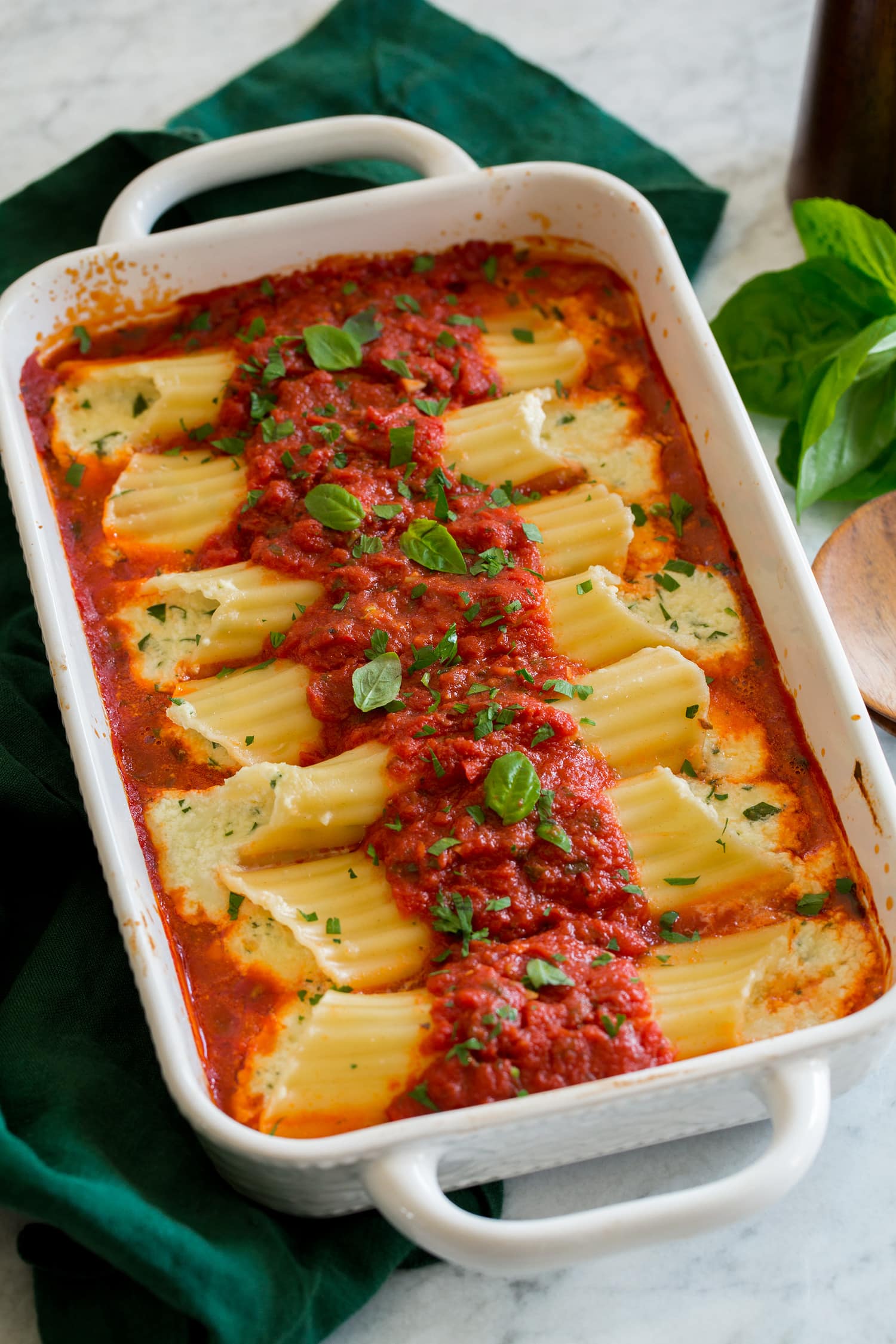 Manicotti Homemade manicotti stuffed with cheese in a baking dish with marinara sauce.