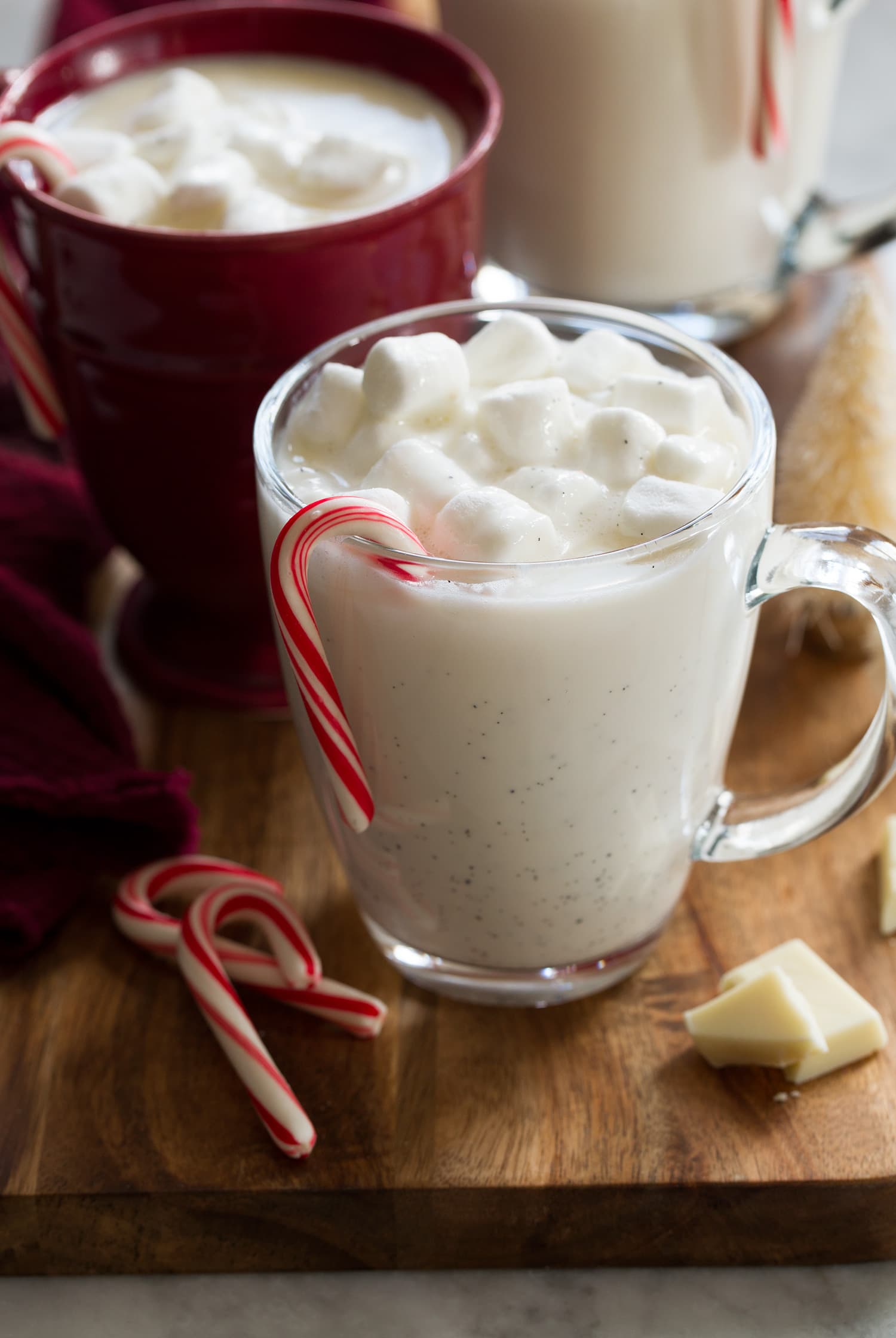 White Hot Chocolate Close up photo of glass mug with white hot chocolate, marshmallows and candy cane.