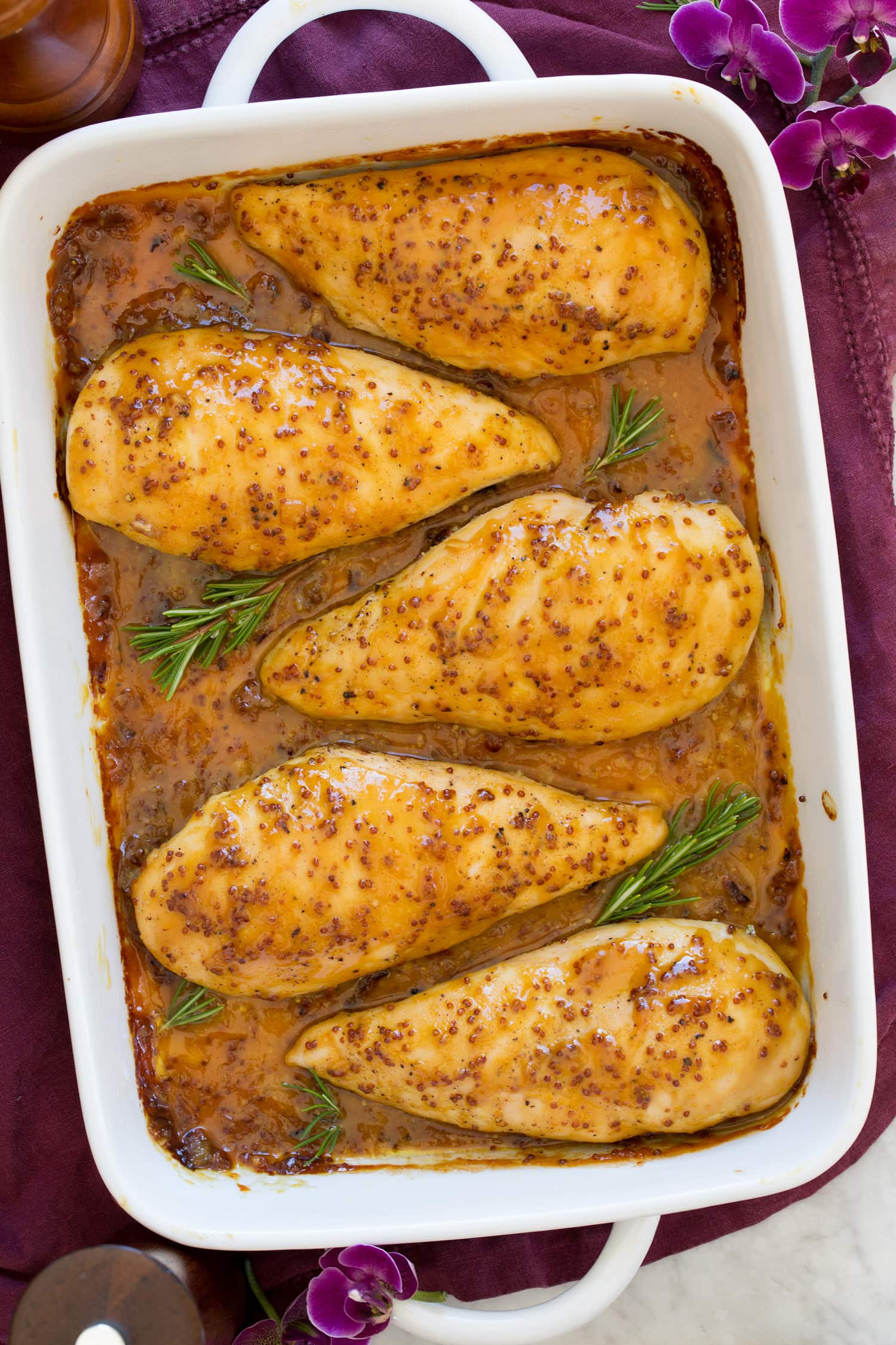 Baked Honey Mustard Chicken Whole grain mustard and honey chicken in white baking dish shown from above.