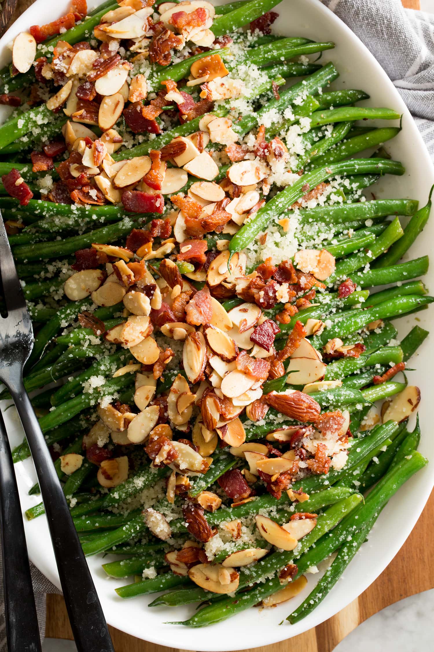 Green Bean Almondine Close up photo of sauteed green beans with almonds, bacon and parmesan.