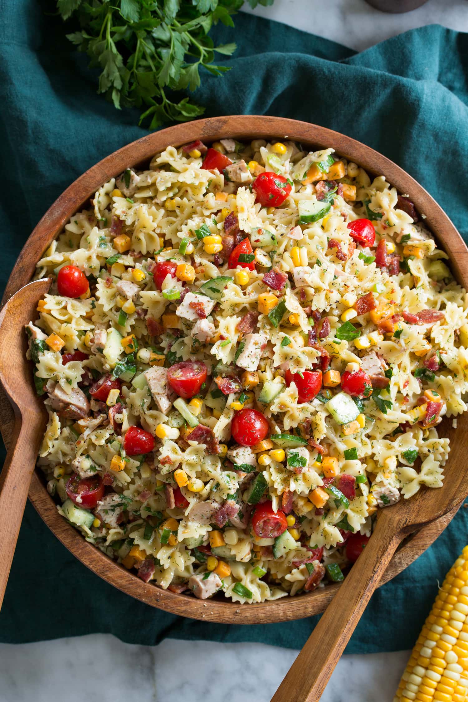 Chicken Pasta Salad Overhead photo of chicken pasta salad in bowl set over a blue cloth on a marble surface.