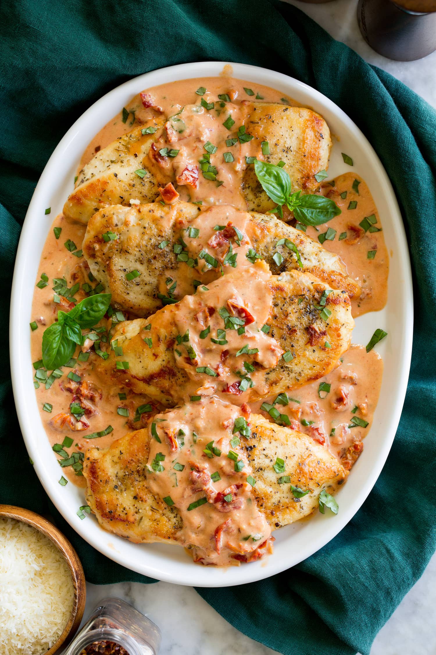 Marry Me Chicken Marry me chicken shown in a row on a white oval platter from above.