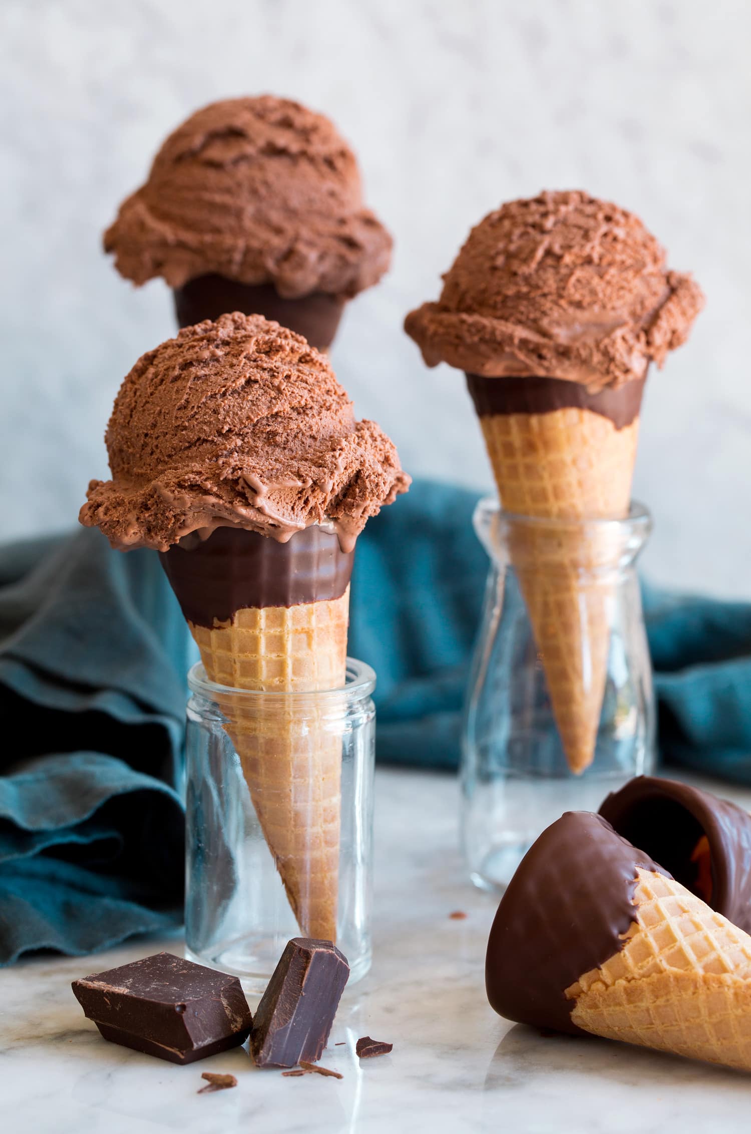 Chocolate Ice Cream Three servings of chocolate ice cream on sugar cones.