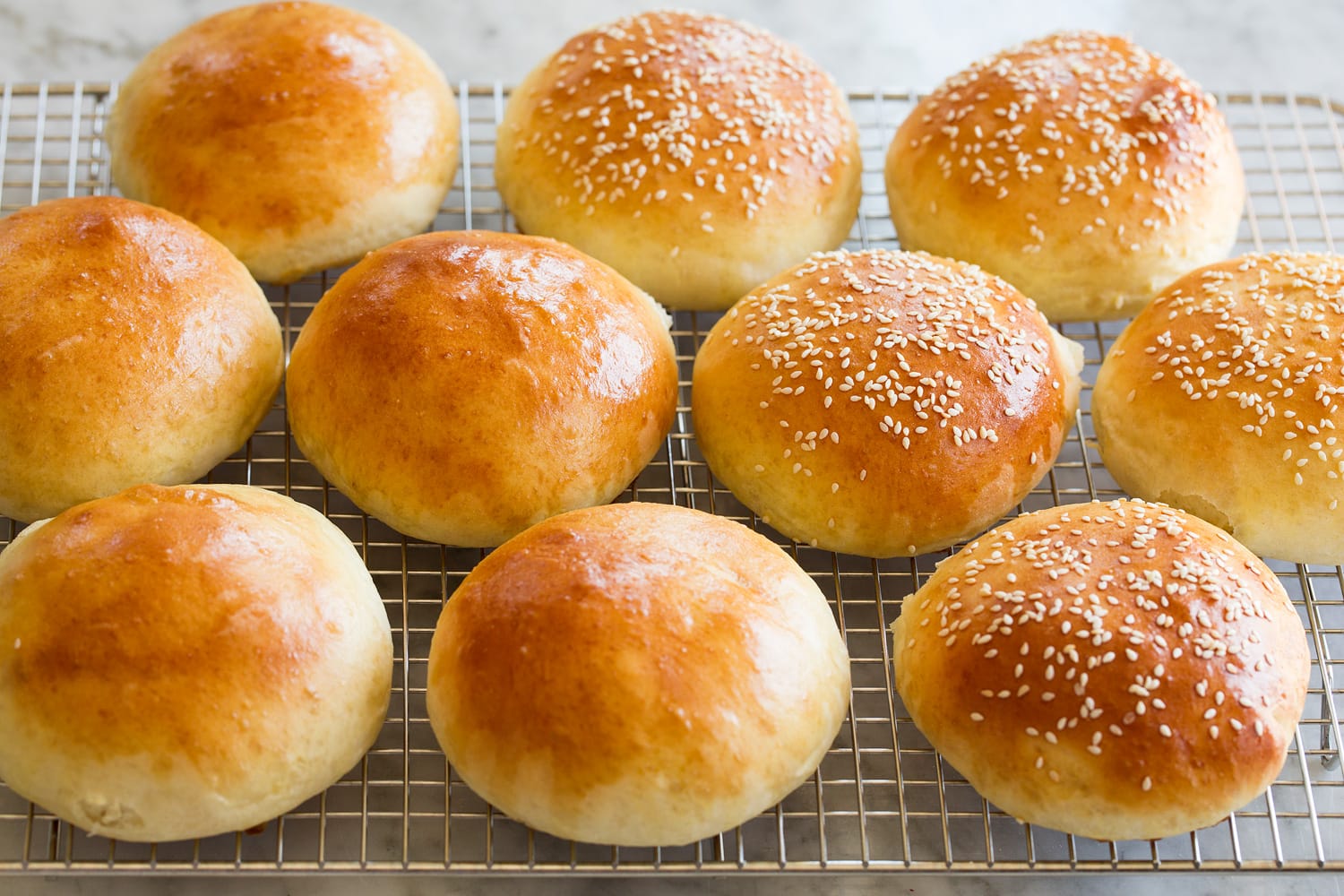 Homemade Hamburger Buns Finished golden brown buns on cooling rack.
