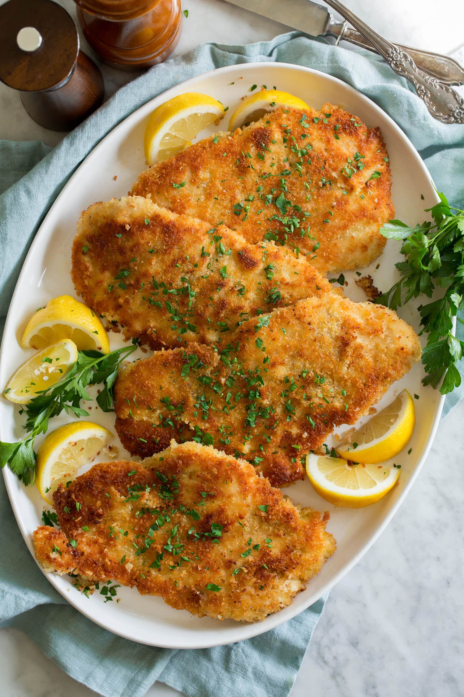 Chicken Schnitzel Overhead photo of four servings of breaded fried thin chicken breasts.