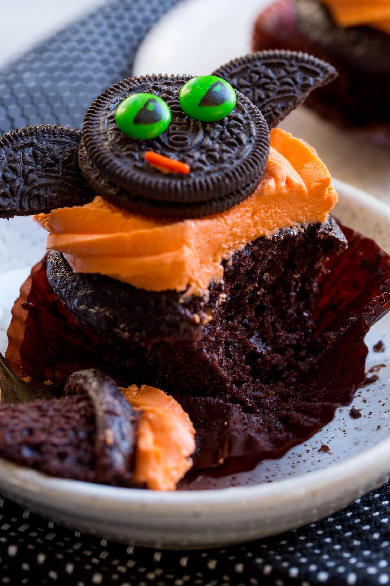 Halloween Cupcakes Chocolate cupcake with orange buttercream shown sliced into to see texture.