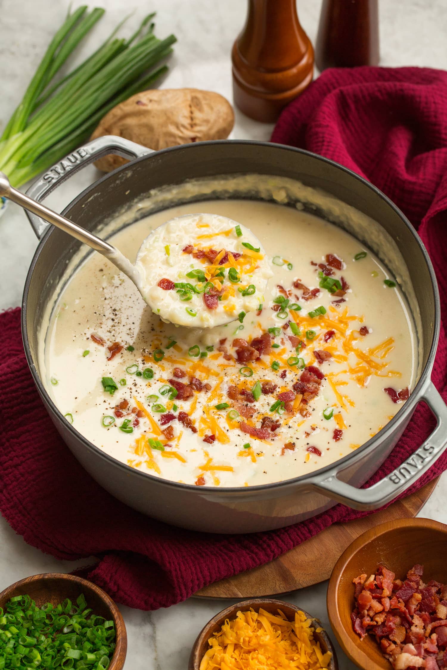 Baked Potato Soup Soup pot with baked potato soup and garnishes.