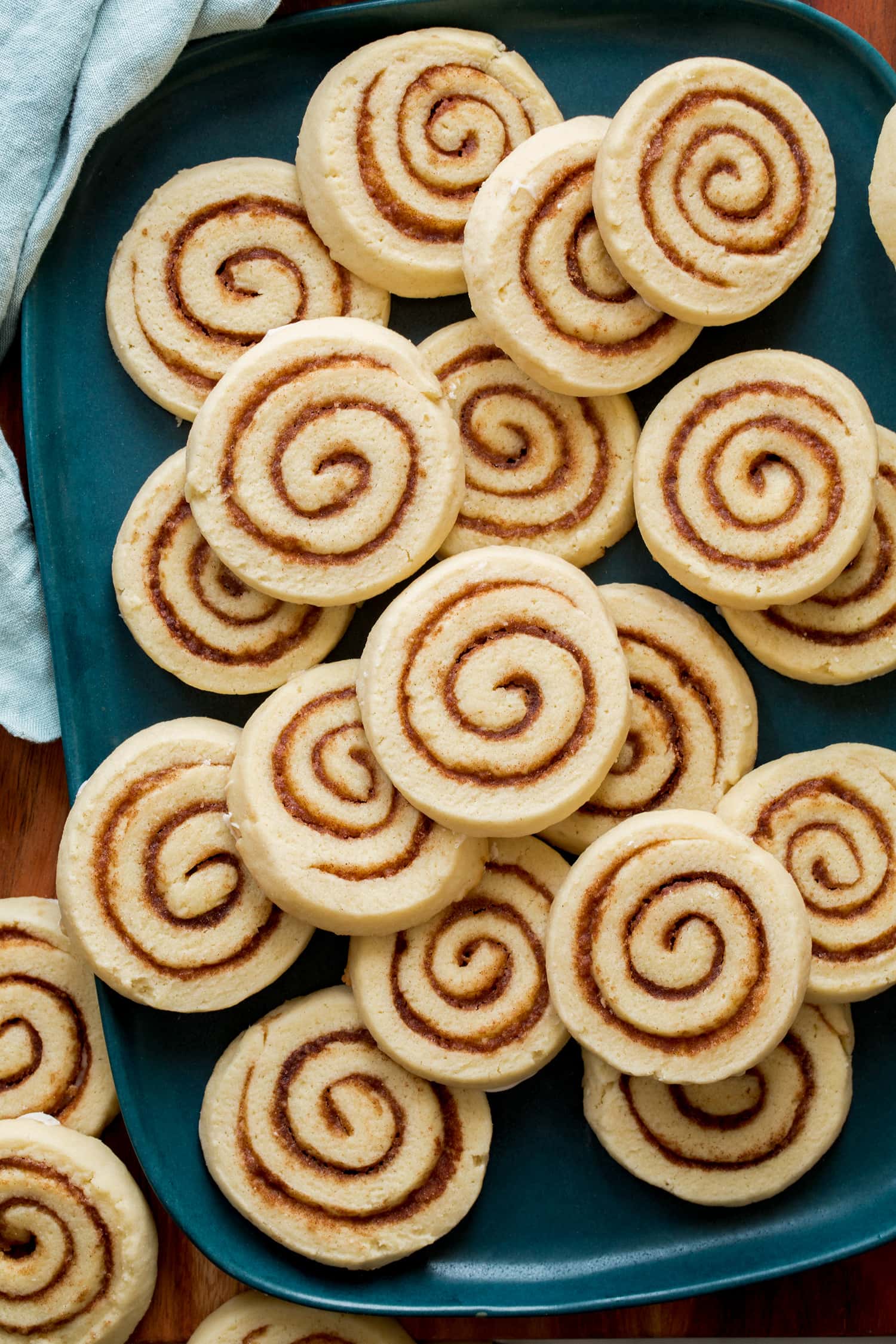 Cinnamon Roll Cookies Cinnamon Roll cookies shown close up on a blue turquoise platter.
