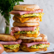 Stack of breakfast sandwiches with eggs, meat and cheese.