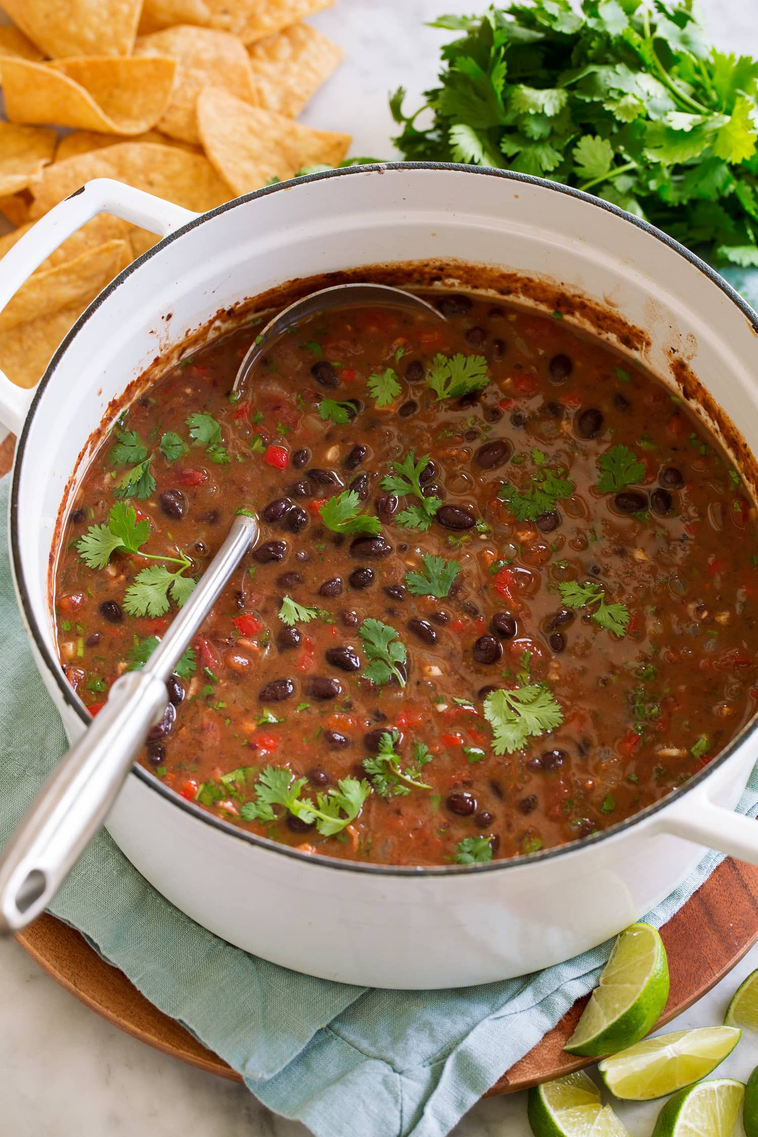 Black Bean Soup Soup with black beans, bell pepper, tomatoes, bacon, spices and cilantro in pot.