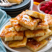 Stack of sheet pan pancakes with butter and syrup.