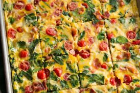 Bacon, tomato, spinach eggs in a baking sheet.