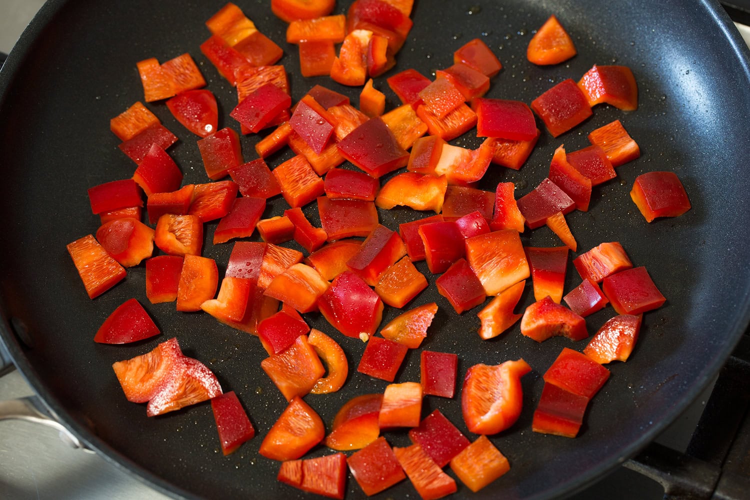 Tofu Scramble Sautéing bell pepper in a dark skillet.