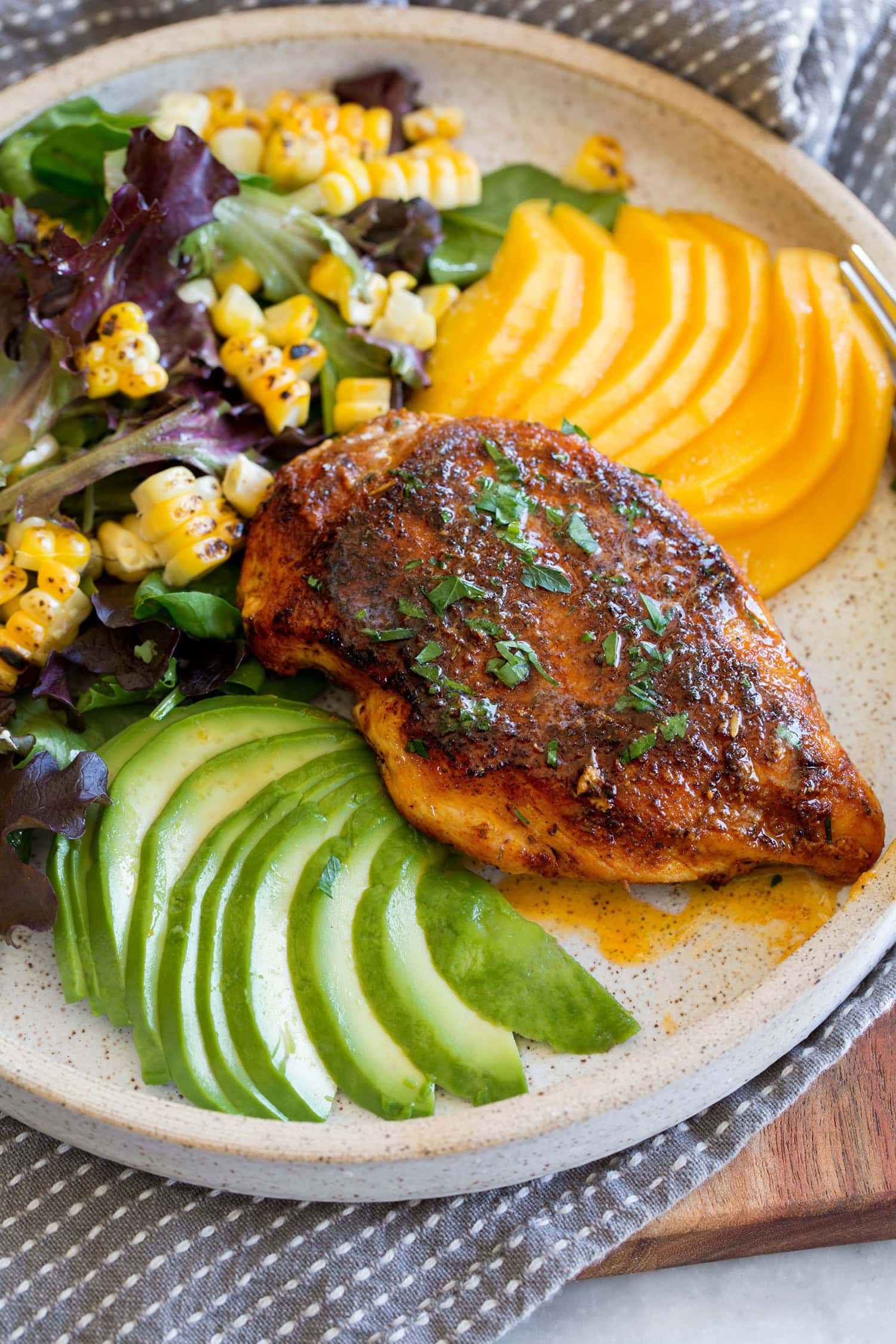 Blackened Chicken Breasts Blackened chicken breasts with serving suggestion of corn salad, mango and avocado.