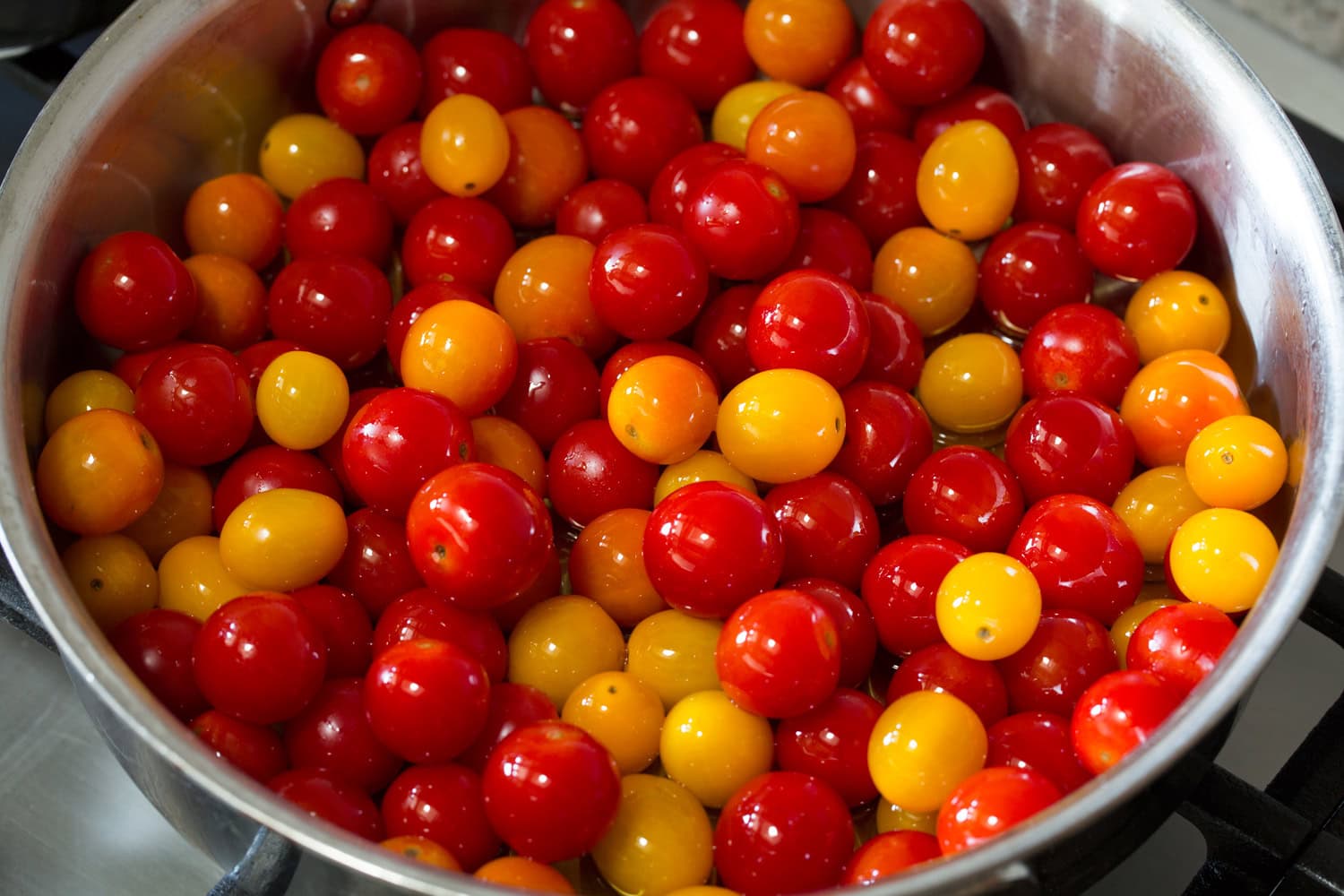Cherry Tomato Pasta Cherry tomatoes and olive oil in a saute pan.