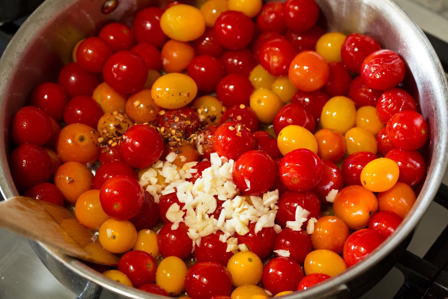 Cherry Tomato Pasta Garlic and red pepper flakes being added to tomato sauce.