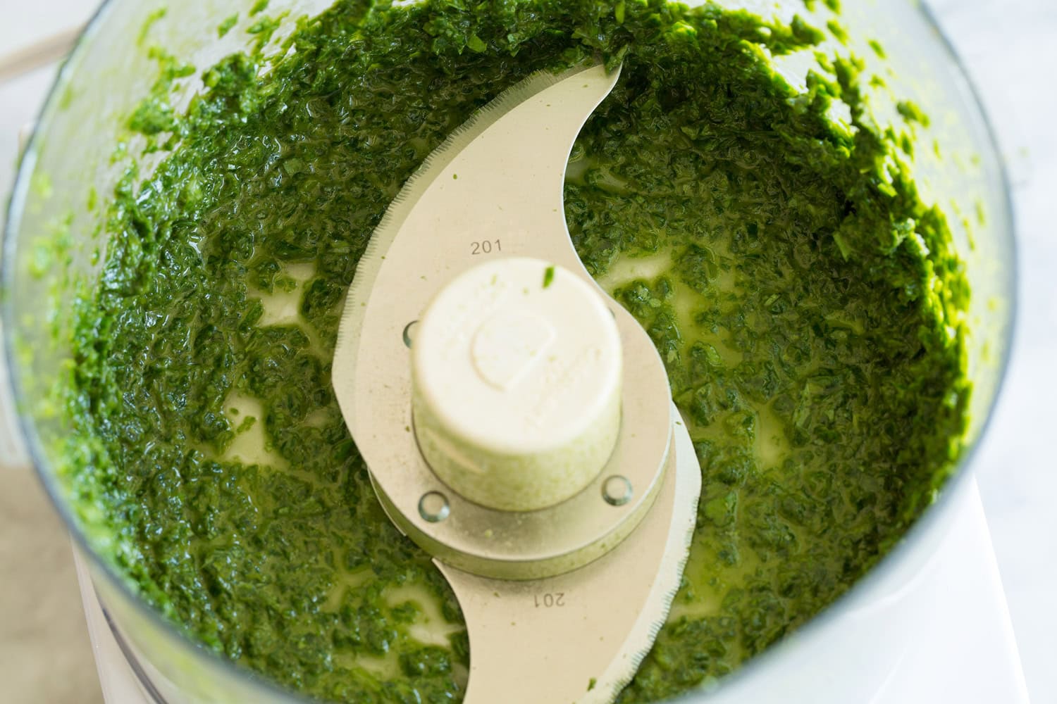 Creamy Pesto Pasta Minced basil oil mixture in food processor.