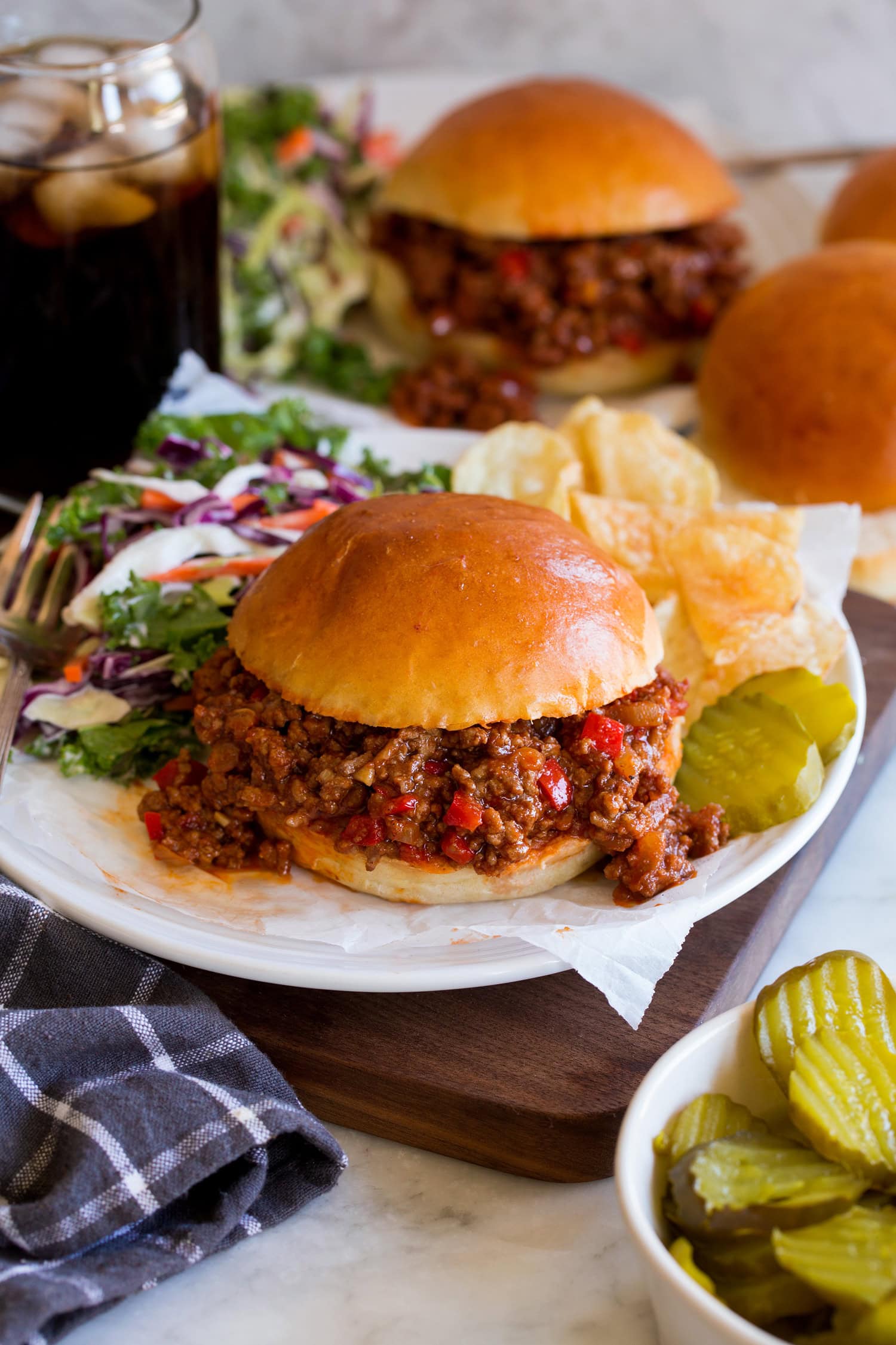 Sloppy Joes Sloppy Joes on a homemade hamburger bun. Served with potato chips, pickles and coleslaw to the side.