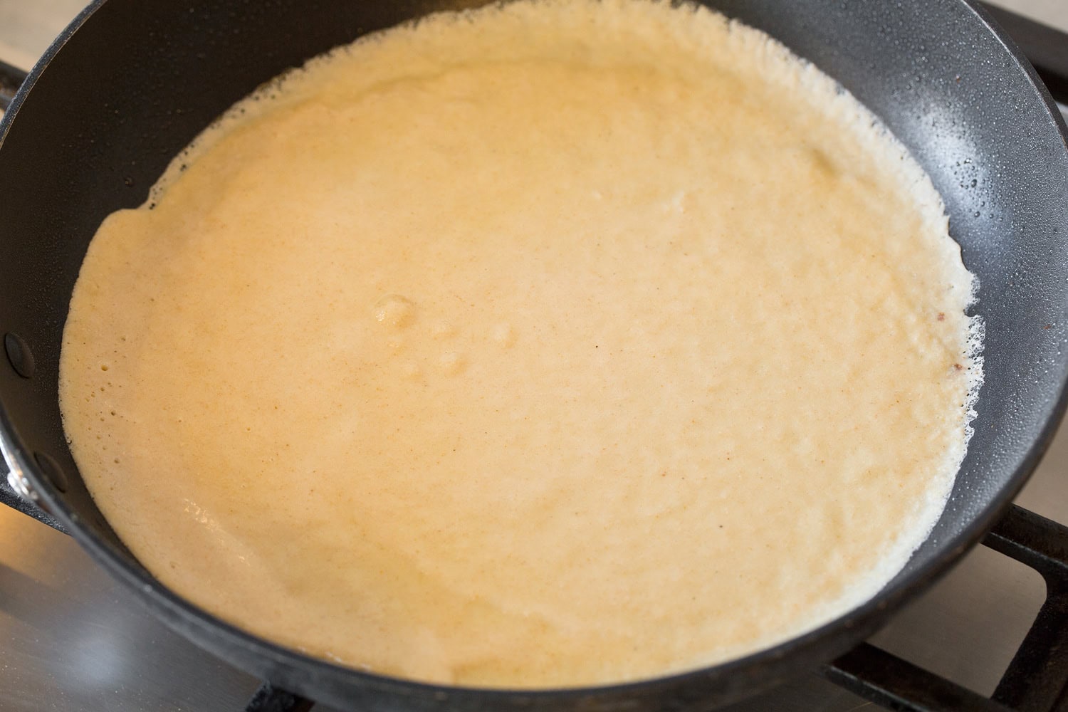 Healthy Oat Crepes Healthy crepe in non-stick pan shown before flipping.