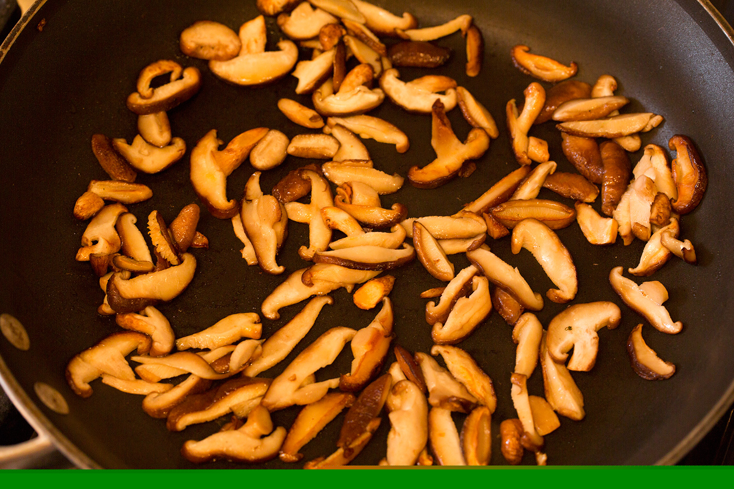 Shitake mushrooms sauteed in a skillet.